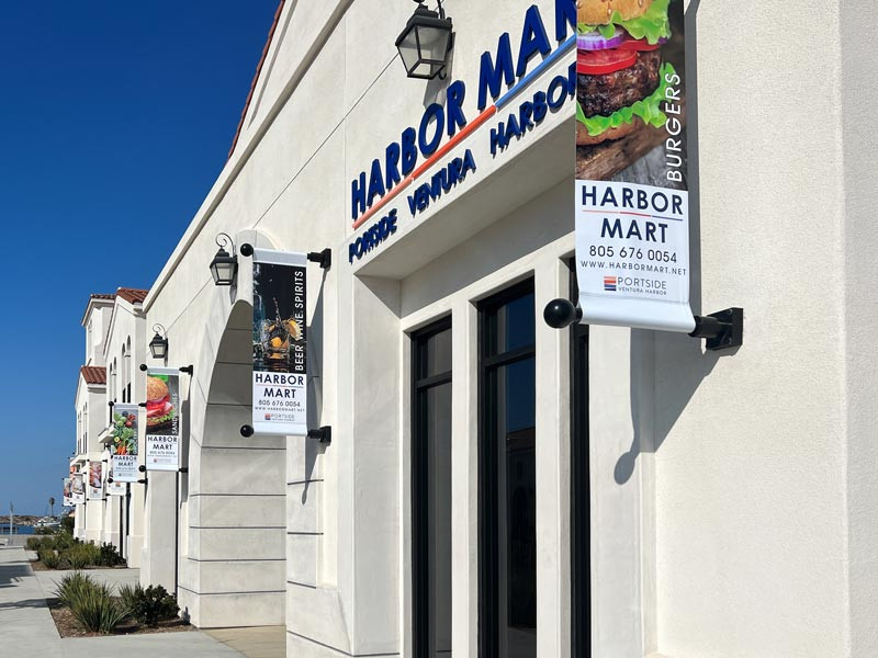 These custom print graphic signs for Harbor Mart in Ventura enhance the outdoor space for shoppers.