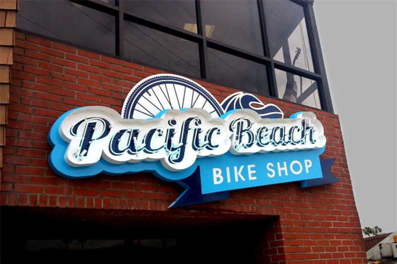 Pacific Beach Bike Shop in San Diego uses neon lit letters and a lightbox or cabinet for “Bike Shop.”