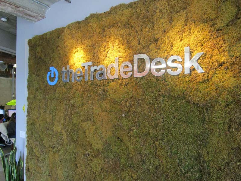 Custom lobby signs – The Trade Desk in Ventura uses brushed aluminum, grass and external overhead lighting.