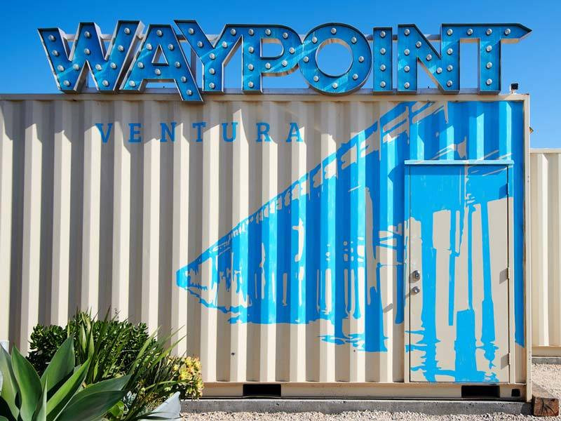 Waypoint Ventura uses metal for their custom signage that includes channel letters mountain atop a shipping container with vinyl graphics.