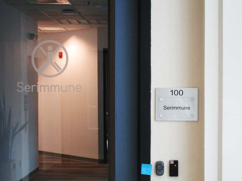 Serimmune uses a frosted vinyl graphic of their logo on the door and wall plaque that matches all the others in the building.