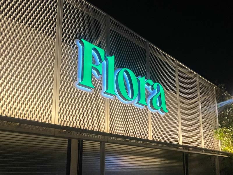 Flora in Los Angeles uses a flush mount for their illuminated channel letter sign. You can't see it, but the wiring is behind the sign.