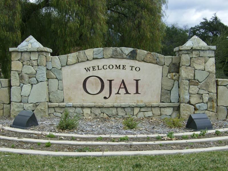 City entry monument sign for Ojai constructed with natural stone masonry, carved lettering, and integrated landscape lighting to create a welcoming architectural gateway.