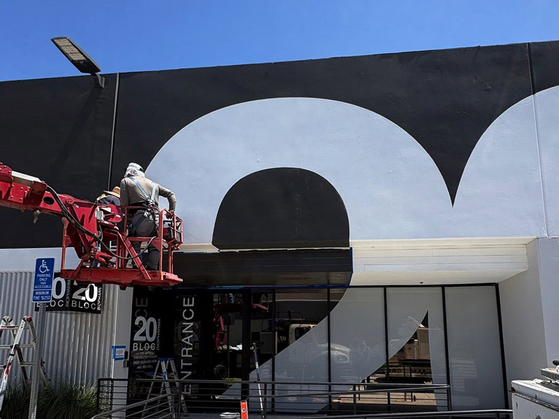 Crew painting a large architectural graphic on the 20 Bloc Biopharma building.