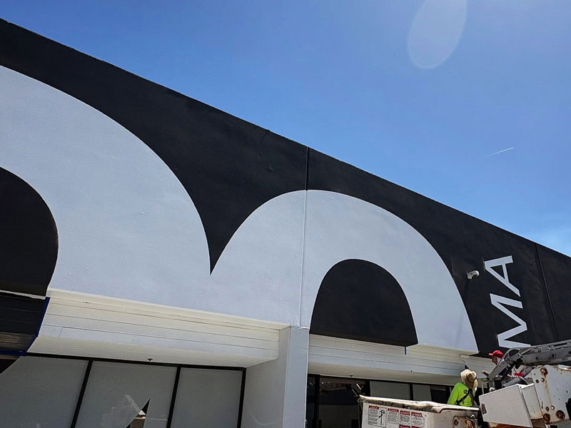 Crew painting a large architectural graphic on the 20 Bloc Biopharma building.