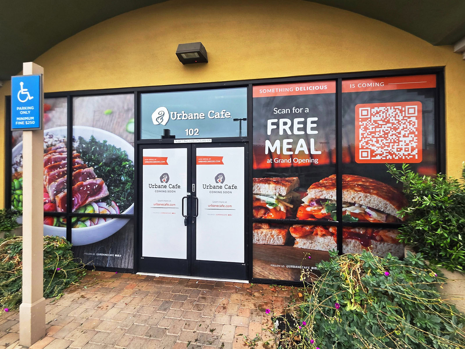 Coming-soon window graphics featuring food photography, grand opening promotion, and QR code at Urbane Cafe in Goleta, CA.